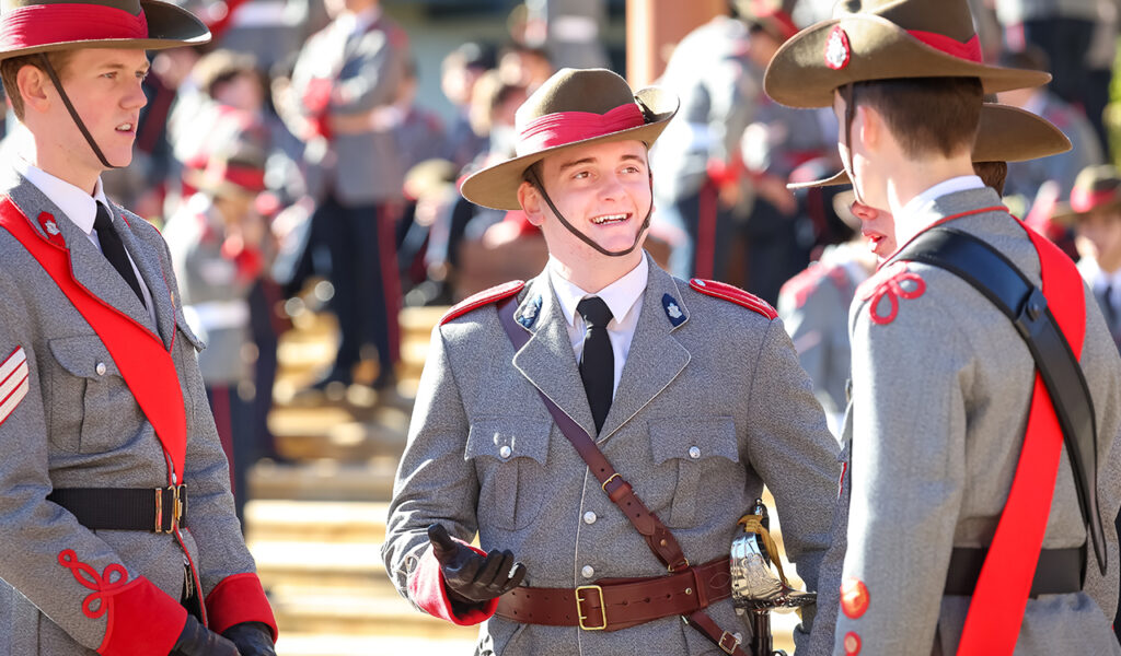 Students in their regimental cadet uniform talking outside