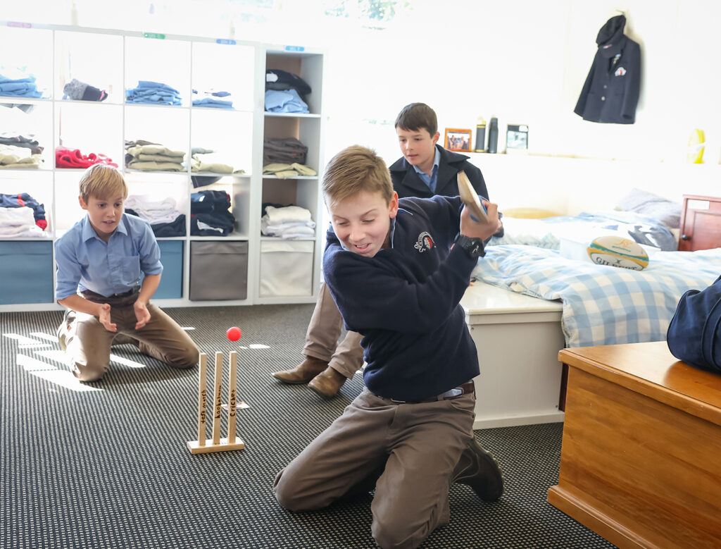 Young male students in uniform playing in boarding room