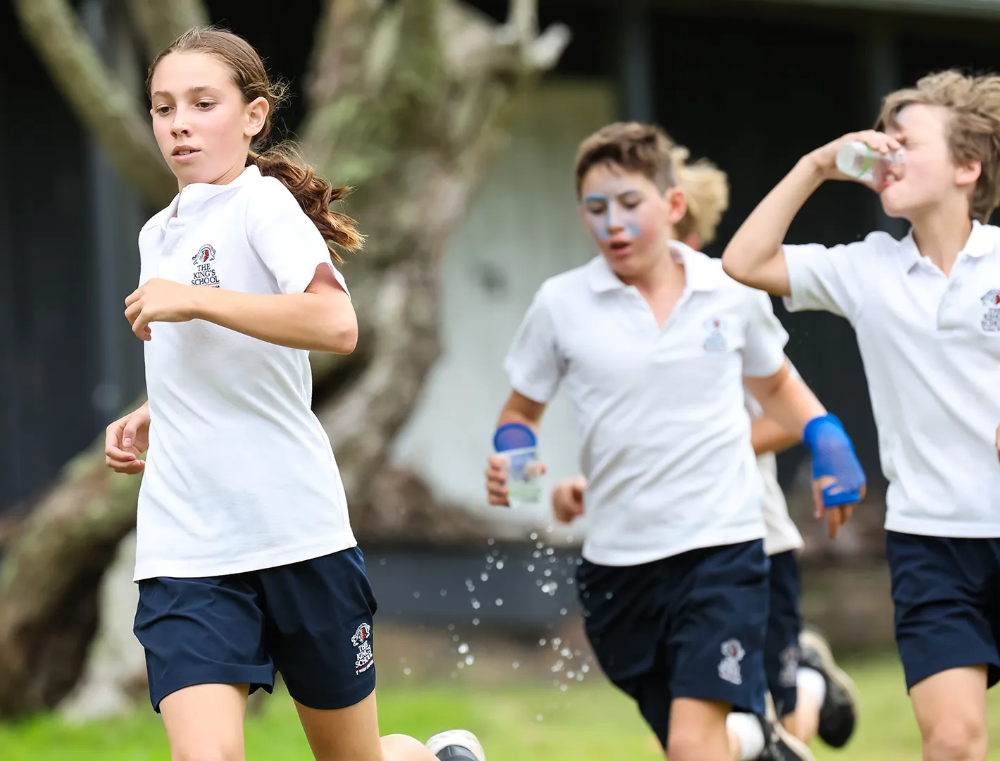 Boys and girls in sports uniforms running in the cross country